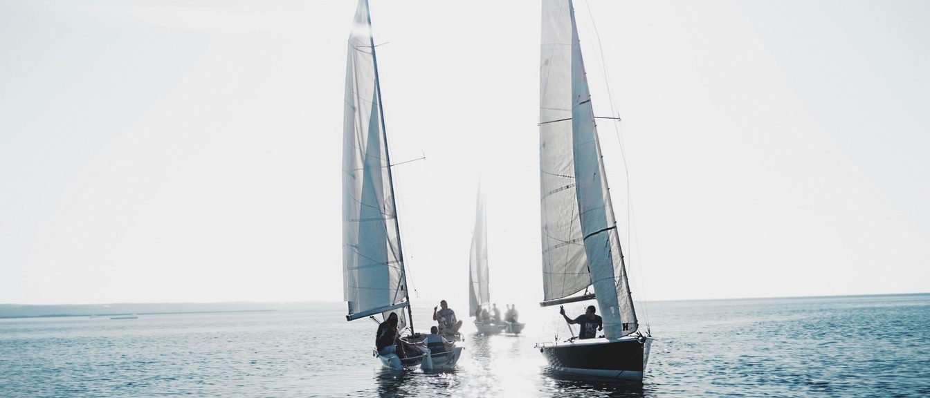 A small sailboat by a dock on a bright morning