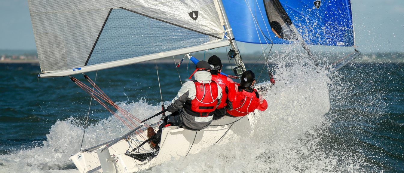 A sailboat under full sail on bright open water